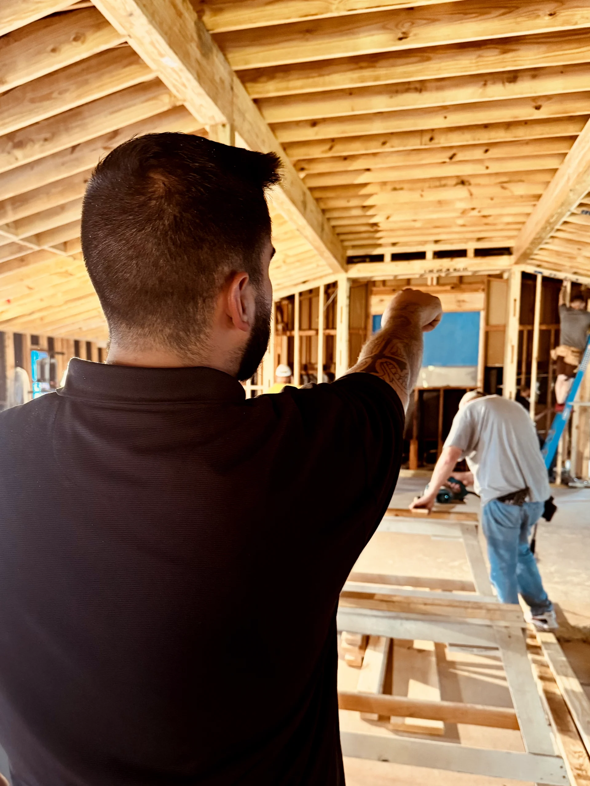 Jacob Merrell pointing during a walkthrough at a commercial framing site